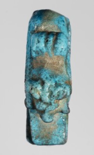 Amulet — ram. Figurine of a ram lying on a flat base, with a loop for hanging on its back. Amulet;
