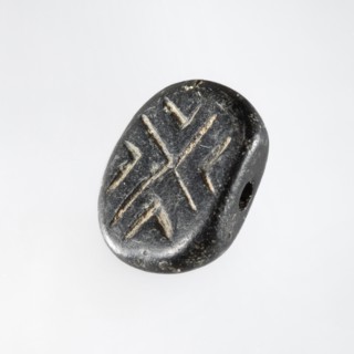 Stamp seal with geometric ornament. A prism-shaped stamp seal with rounded edges and an oval,