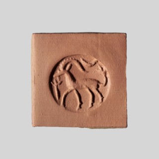 Conical stamp seal with a hole drilled below the top of the cone. On the circular base is engraved