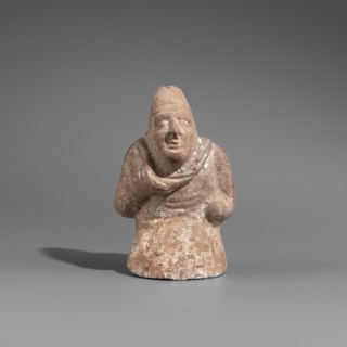 Hunchback puppet. Figurine hollow inside. Hunchbacked torso with a large head in a pointed cap set