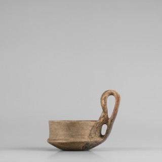 A miniature kyatos with a flat bottom and a bowl whose walls widen diagonally almost halfway up and