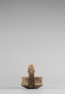 A miniature kyatos with a flat bottom and a bowl whose walls widen diagonally almost halfway up and