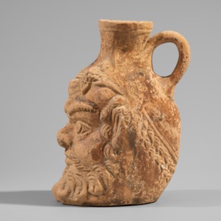 Vessel with a belly in the shape of a satyr's Silenus's head. A flat-bottomed vessel with a plastic