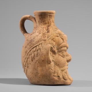 Vessel with a belly in the shape of a satyr's Silenus's head. A flat-bottomed Roman pottery vessel