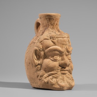 Vessel with a belly in the shape of a satyr's head, unknown Pergamon workshop. A flat-bottomed