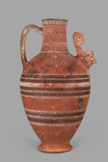 Jug with a figurine of a woman with a jug. Cypriot pottery, female figurines applique. Jug on a