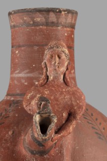 Jug with a figurine of a woman with a jug. Cypriot pottery, female figurines applique. Jug on a