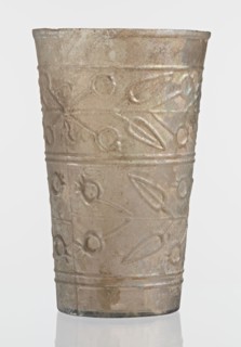 Glass decorated with a leaf and fruit motif; transparent, colorless glass with relief decoration in