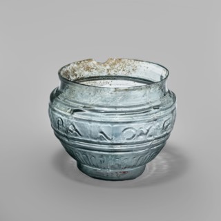 Glass bowl with Greek inscription. Transparent light-blue glass, uneven rim edge, cold-worked.
