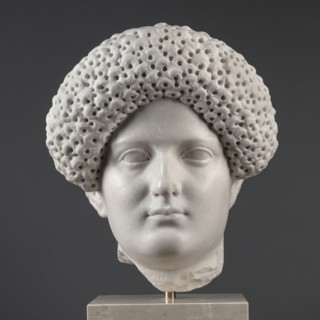 Portrait of a Roman woman, Head with a broad face and an elaborate hairstyle: hair twisted into