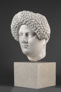 Portrait of a Roman woman, head with a broad face and an elaborate hairstyle: hair twisted into