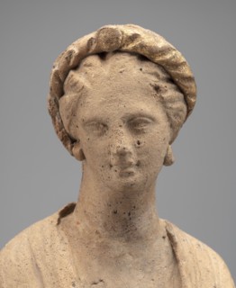 Female Figurine. Standing woman dressed in a long robe, slightly pleated and belted high under the