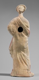 Figurine of a maenad. A young woman standing in a wreath tied with a ribbon is dressed in a chiton