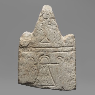 Votive stele with the sign Tanit, unknown Carthaginian workshop. Upper part of a stele with
