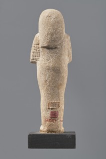 Ushabti, Mummy-shaped figurine made of limestone. Arms crossed on the chest, the right folded over