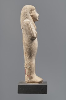 Ushabti, Mummy-shaped figurine made of limestone. Arms crossed on the chest, the right folded over