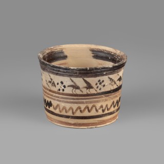 Pyxis with a duck motif. Ceramic vessel pyxis of yellowish clay with dark brown matte paint and