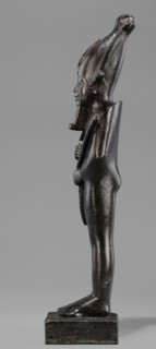 Figurine of the god Osiris. Statuette of a standing Osiris wrapped in a long, tight-fitting robe