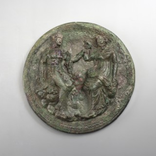 Mirror cover with an image of a couple. The bronze cover is decorated with a figurative scene of