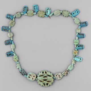 Necklace of 33 amulets and plaques, separated by tiny spherical beads several, usually 3 in a row,