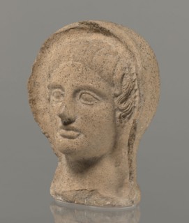 Votive head, Head of a young man covered with a shawl, from under which hair emerges in the form of