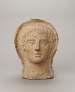 Votive head, Head of a young man covered with a shawl, from under which hair emerges in the form of
