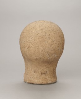 Votive head, Head of a young man covered with a shawl, from under which hair emerges in the form of