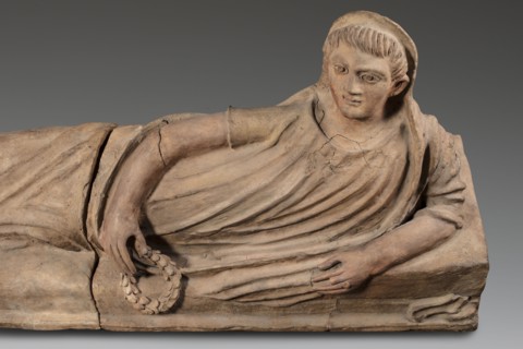 Sarcophagus lid, The deceased is depicted in a semi-reclining position, resting his left forearm on