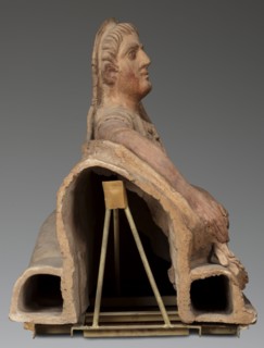 Sarcophagus lid, in a semi-reclining position. The deceased rests his left forearm on a pillow and