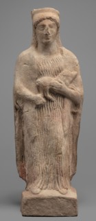 Figurine of a woman with a polos on her head, holding a piglet. Figurine of a woman standing on a