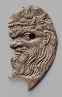 Decoration in the shape of the head of Silenus. Relief appliqué of the head of Silenus, depicted in