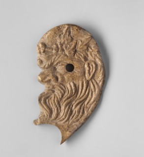 Decoration in the shape of the head of Silenus. Relief appliqué of the head of Silenus depicted in