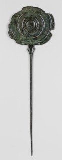Pin, unknown Luristan workshop. A long pin terminating in a head in the form of an oval shield with