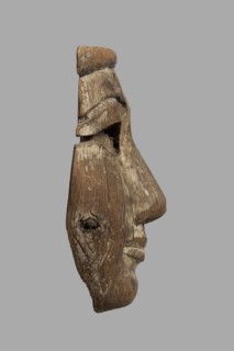 Fragment of a sarcophagus mask. Preserved half of a face made from a single piece of wood. Above