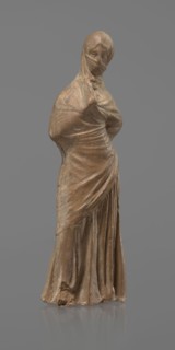 Terracotta figurine of a veiled woman, dancer, molded Tanagra figurine in fine-grained red clay.