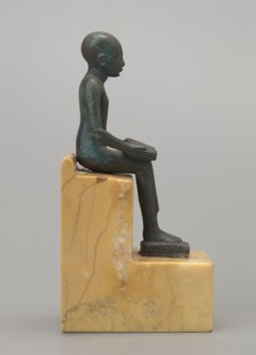 Figurine of Imhotep: seated Imhotep holding an unrolled papyrus on his lap, palms of both hands