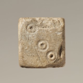 Six-sided dice with pips 1–6 shown as hollow circles and dots; material unspecified; maker and