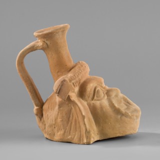 Vessel with a belly in the shape of a comic mask, unknown Greek workshop; plastic vessel with