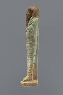 Ushabti, mummy-shaped figurine, funerary gift, hoes. Mummy-shaped figurine standing on a base,