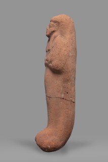 Ushabti. Funerary mummy-shaped figurine, arms crossed on the chest, no tools. On the head is a