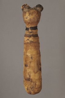 Cat mummy decorated with a meander made of white and brown bandages. Cat mummy, linen fabrics;