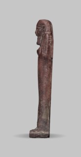 Ushabti, A shabti figurine dressed in a shroud stands on a base. On the head is a smooth wig
