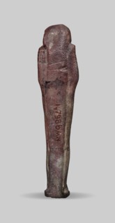 Ushabti, A shabti figurine dressed in a shroud stands on a base. On the head is a smooth wig