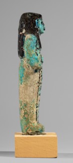Shabti of the Lady of Renu, Mummy-shaped funerary figurine made of blue faience with dark details.