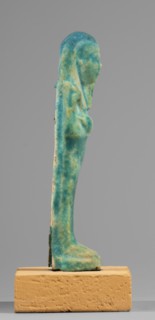 Ushabti, mummy-shaped funerary figurine standing on a base, supported at the back by a flat