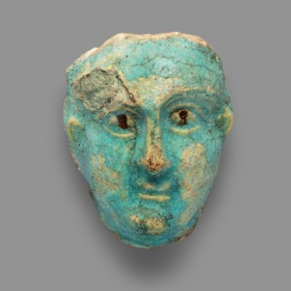 Fragment of a figurine. Oval male face with a protruding chin, small mouth, straight nose, and