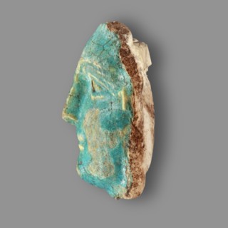 Fragment of a figurine. Oval male face with a protruding chin, small mouth, straight nose, and