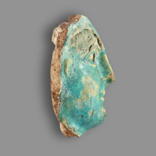 Fragment of a figurine. Oval male face with a protruding chin, small mouth, straight nose, and