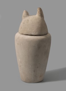 Canopic jar with a jackal's head, canopic jars; jackals; Duamutef mythology. The vessel widens