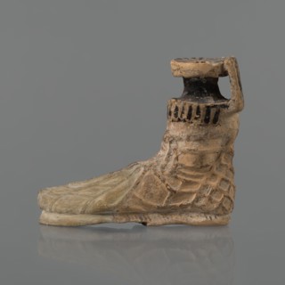 Foot-shaped aryballos, aryballos, antique vessel; yellow-orange clay with mica; matte black engobe